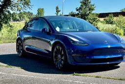 2023 Tesla Model 3 in blue parked outside,